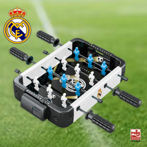 Futbolín de mesa con diseño del Real Madrid, con jugadores blancos y azules sobre fondo de campo de fútbol.